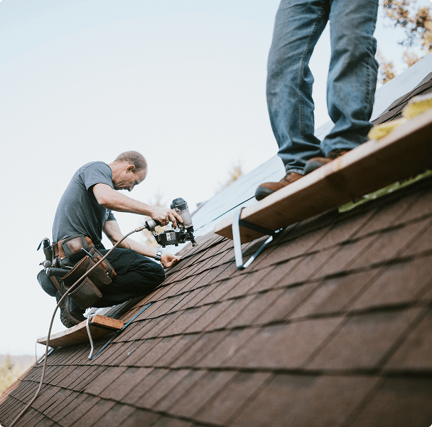 Roofers working on a shingled roof.